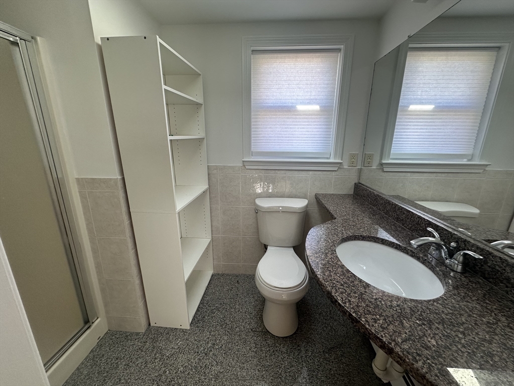 206 Adams Street, Unit 206 Newton, MA 02458 - Photo 20 of 37 a bathroom with a granite countertop sink and a mirror
