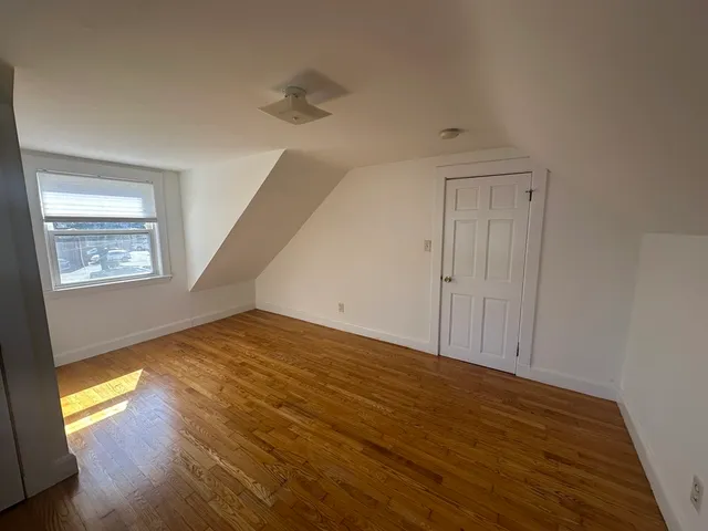 a view of a room with wooden floor and window