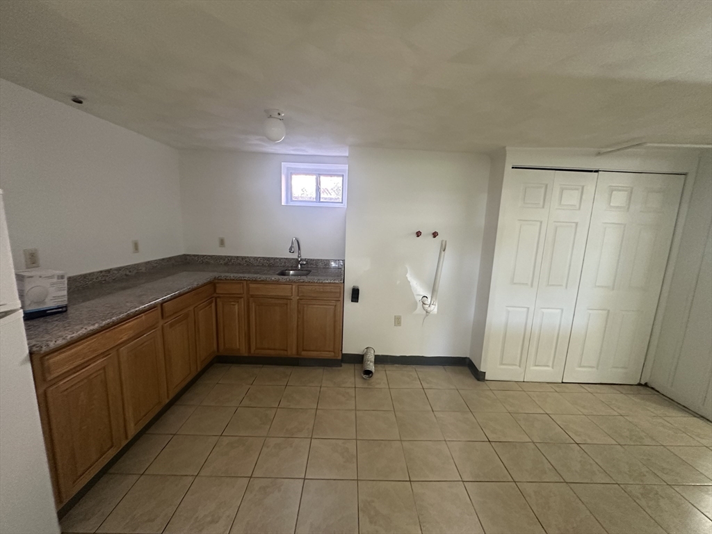 206 Adams Street, Unit 206 Newton, MA 02458 - Photo 30 of 37 a kitchen with a sink a counter and cabinets