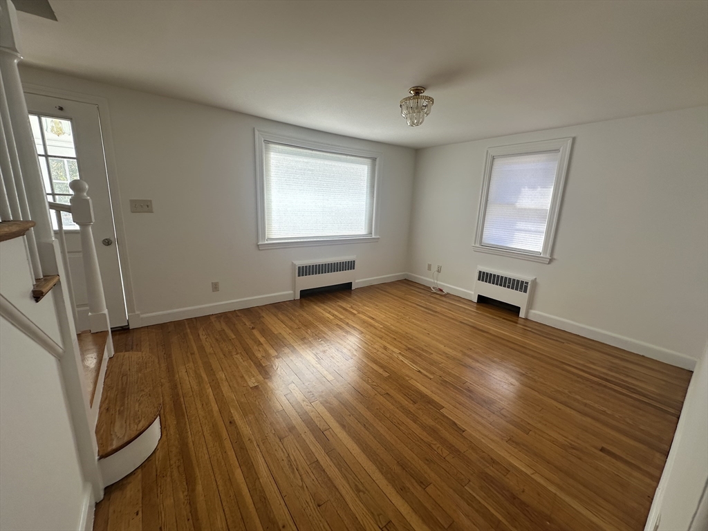 206 Adams Street, Unit 206 Newton, MA 02458 - Photo 3 of 37 a view of an empty room with wooden floor and a window