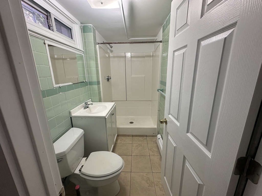 206 Adams Street, Unit 206 Newton, MA 02458 - Photo 34 of 37 a bathroom with a sink a toilet a mirror and a shower