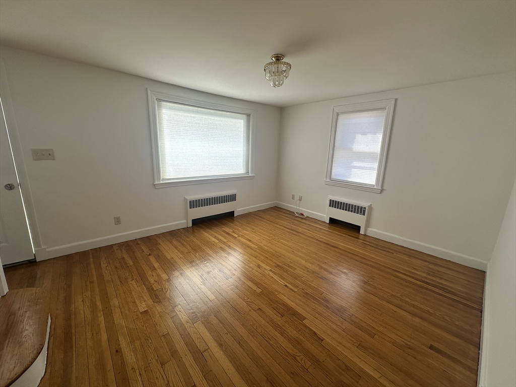 206 Adams Street, Unit 206 Newton, MA 02458 - Photo 4 of 37 a view of empty room with wooden floor and fan