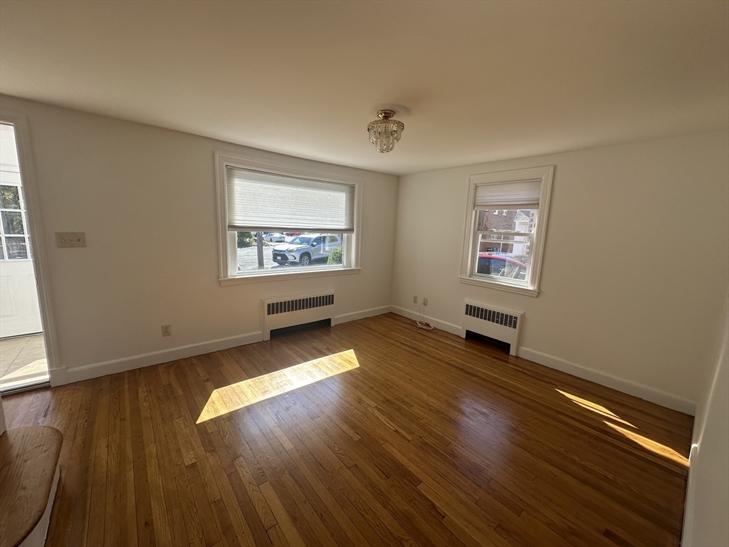 206 Adams Street, Unit 206 Newton, MA 02458 - Photo 6 of 37 a view of an empty room with wooden floor and a window