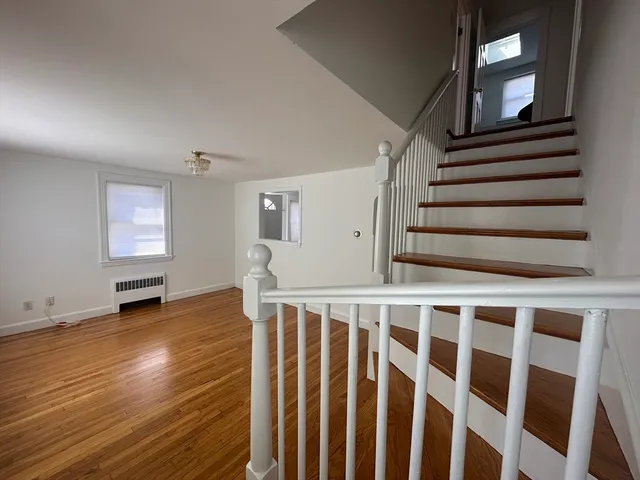 a view of wooden floor in a hall with a window