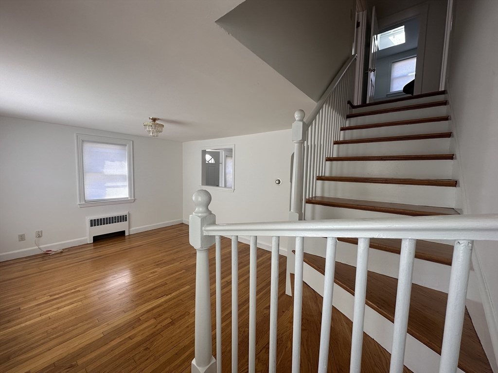 206 Adams Street, Unit 206 Newton, MA 02458 - Photo 10 of 37 a view of wooden floor in a hall with a window