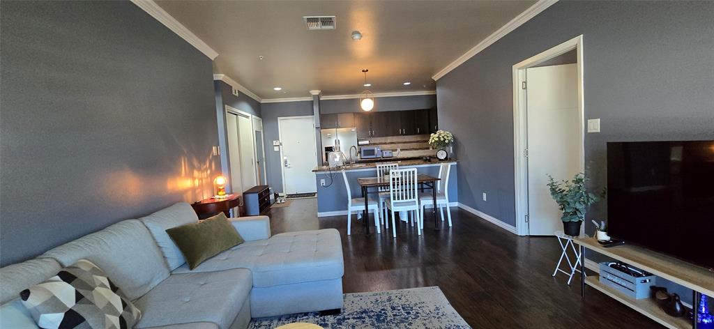 1100 West Trinity Mills Road, Unit 2045 Carrollton, TX 75006 - Photo 2 of 20 Living area featuring dark wood finished floors, ornamental molding, and recessed lighting