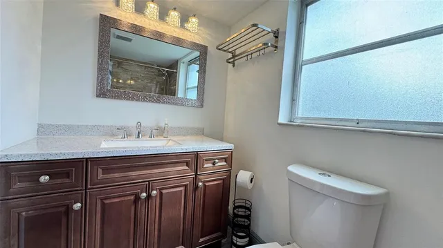 a bathroom with a sink mirror vanity and toilet