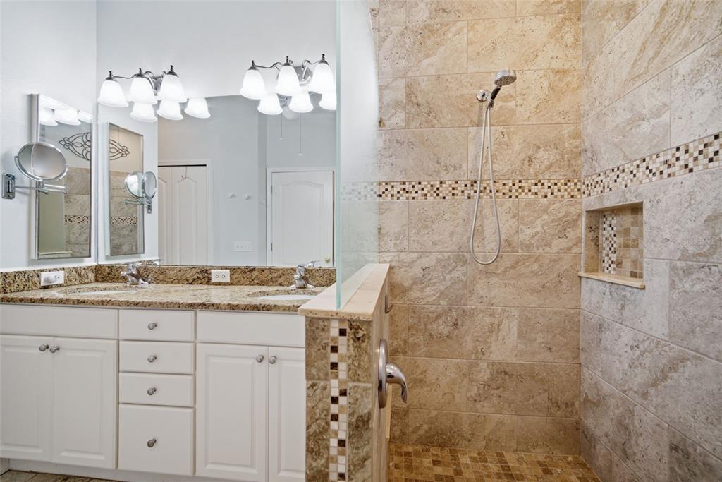 6057 Sandhill Ridge Drive Lithia, FL 33547 - Photo 30 of 83 a bathroom with a granite countertop sink a mirror and a shower