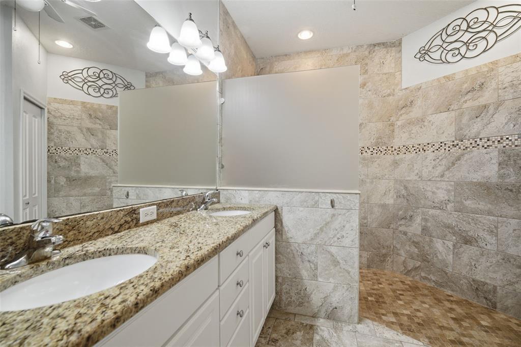 6057 Sandhill Ridge Drive Lithia, FL 33547 - Photo 4 of 83 a bathroom with a granite countertop double vanity sink and a mirror