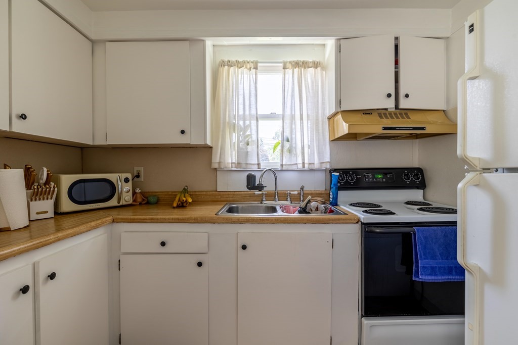 102 Mendon Street Blackstone, MA 01504 - Photo 11 of 41 a kitchen with stainless steel appliances a stove a sink a refrigerator and cabinets