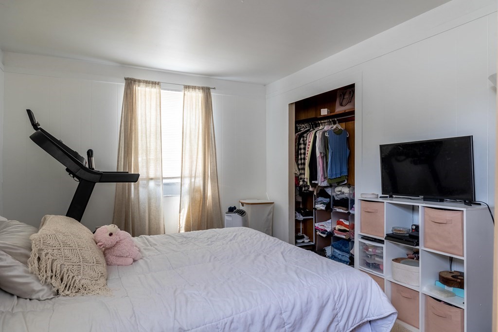 102 Mendon Street Blackstone, MA 01504 - Photo 14 of 41 a bedroom with a bed and a flat tv screen on the dresser