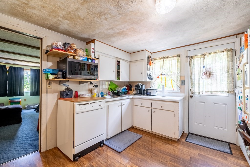 102 Mendon Street Blackstone, MA 01504 - Photo 25 of 41 a kitchen with stainless steel appliances a stove top oven a sink dishwasher and a refrigerator with wooden floor