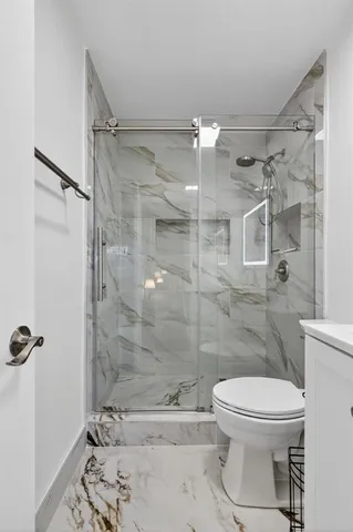 a bathroom with a toilet and a shower