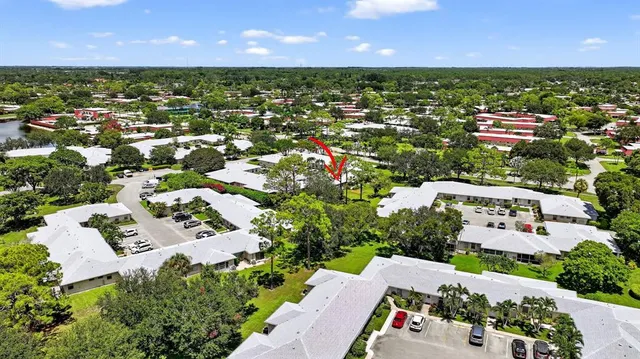 an aerial view of residential houses with outdoor space and trees