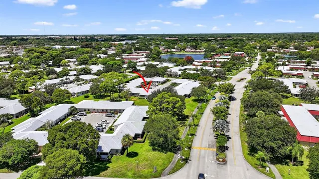 an aerial view of residential houses with outdoor space and trees