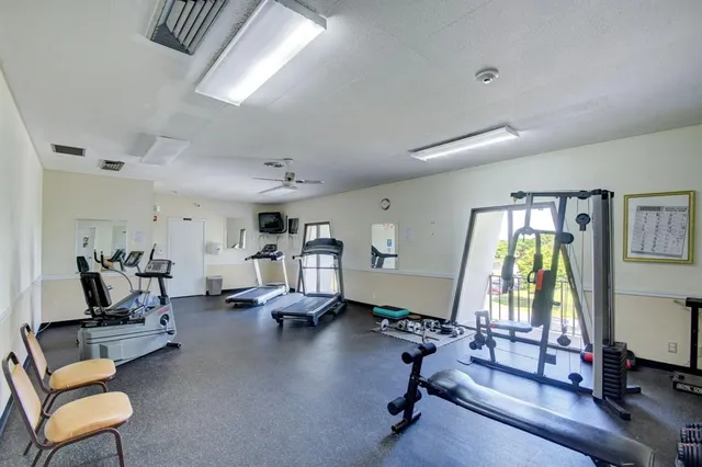 a living room with furniture gym equipment and a large window