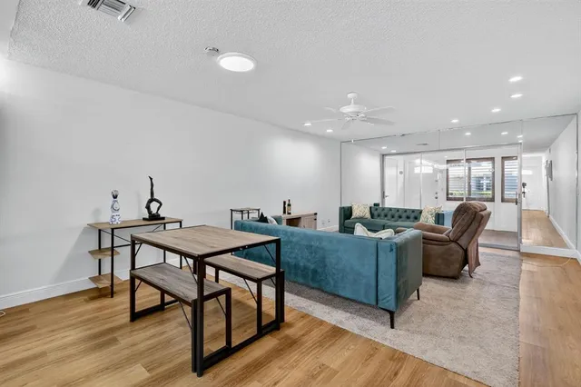a living room with furniture a wooden floor and potted plants