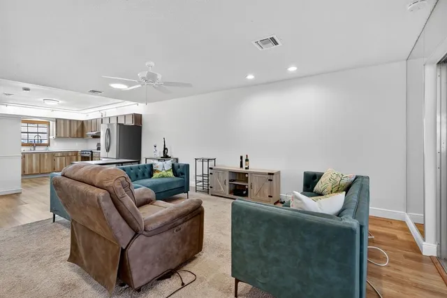 a living room with furniture and a wooden floor