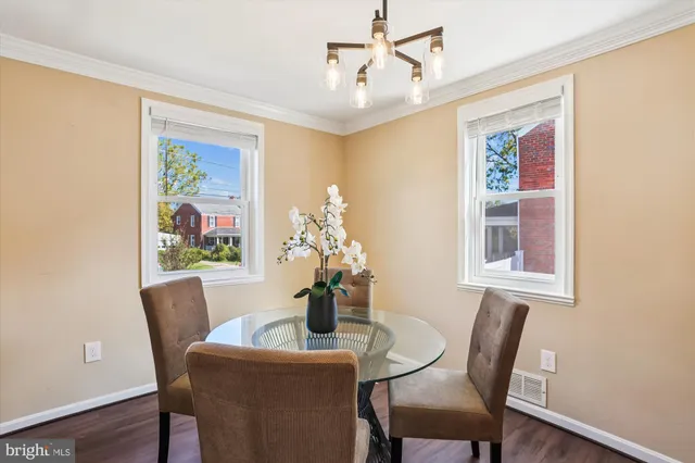 a view of a dining room with furniture a chandelier and wooden floor