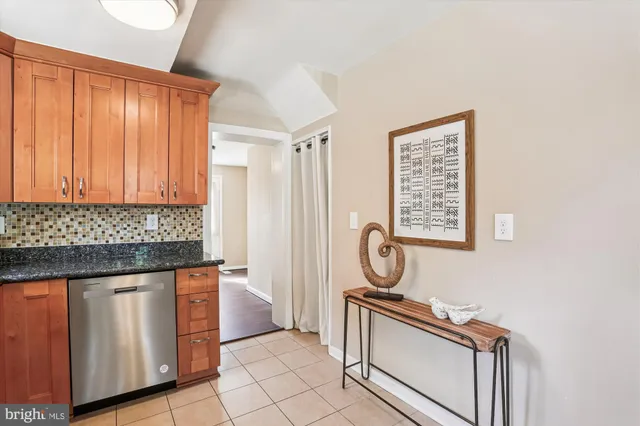 a kitchen with granite countertop stainless steel appliances a stove sink and cabinets