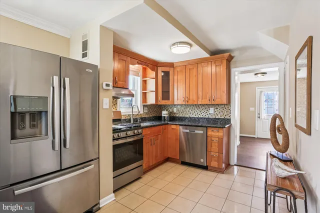 a kitchen with granite countertop stainless steel appliances a stove a sink a dining table and chairs