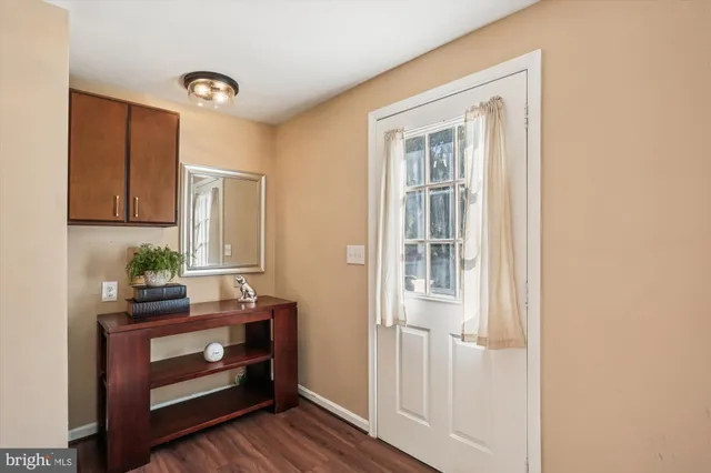 a view of a hallway with wooden floor fireplace and living room