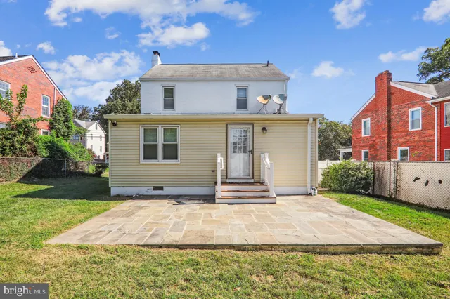 a backyard of a house with table and chairs