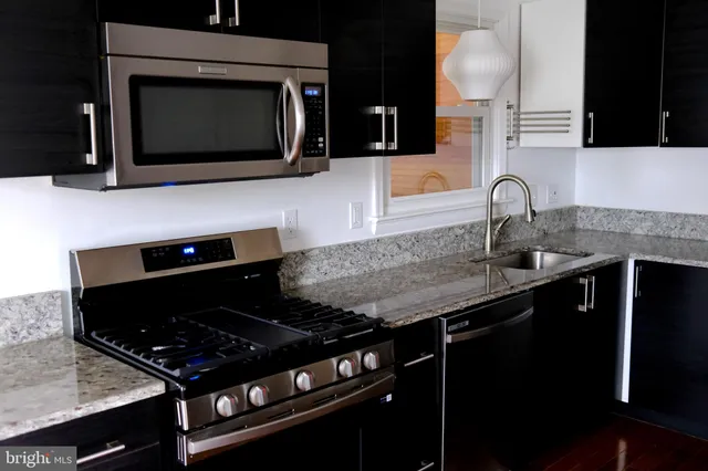 a kitchen with granite countertop stainless steel appliances and sink