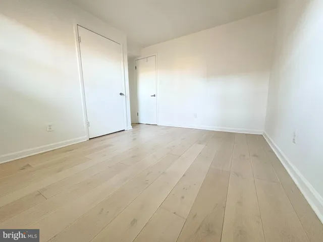 a kitchen with stainless steel appliances granite countertop a sink dishwasher a refrigerator and a stove with wooden floor