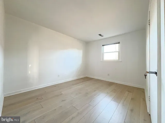 a view of an empty room with cabinet and stairs