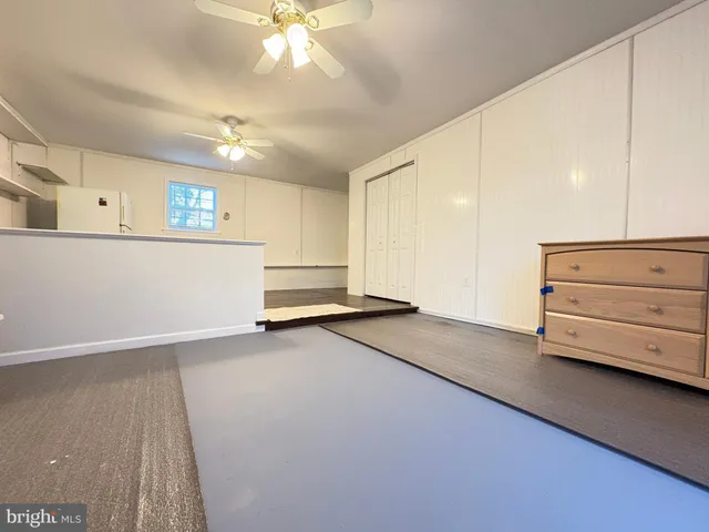a view of a livingroom with a furniture hardwood floor and ceiling fan