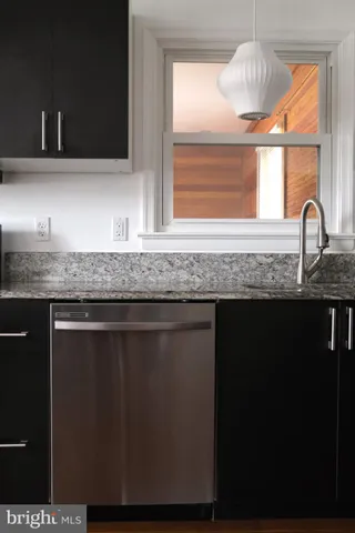 a kitchen with granite countertop a sink a window and stainless steel appliances