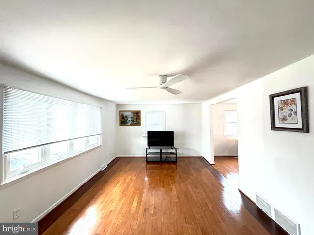 a view of a room with wooden floor and a window
