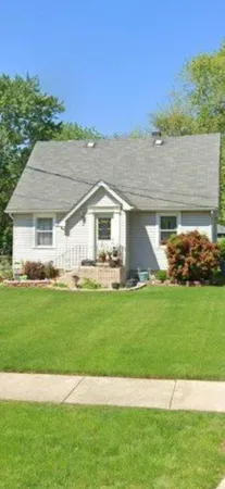 a front view of a house with a garden and yard