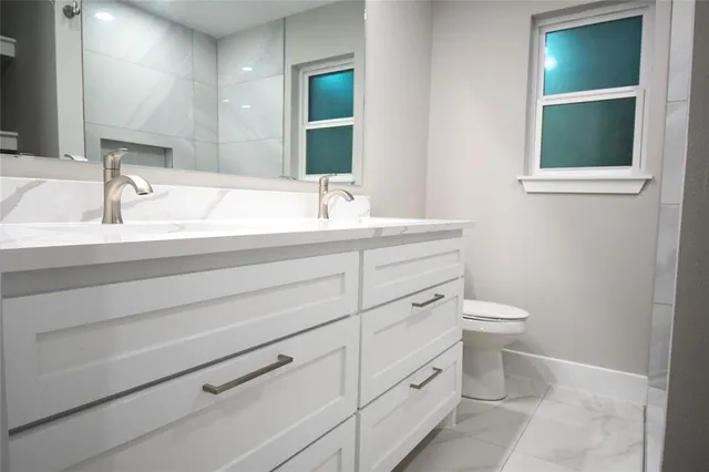 a bathroom with a toilet sink and mirror
