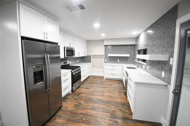 a large kitchen with a stove a sink and a refrigerator