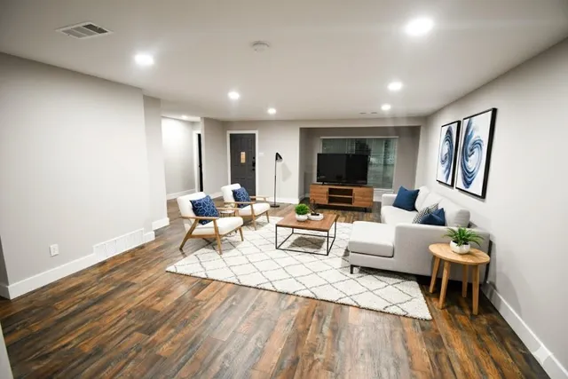 a living room with furniture and a wooden floor