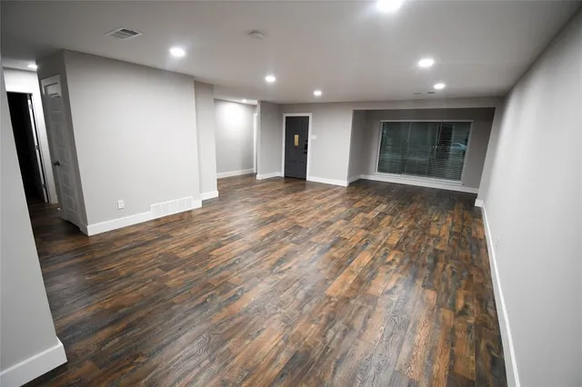 an empty room with wooden floor and a window