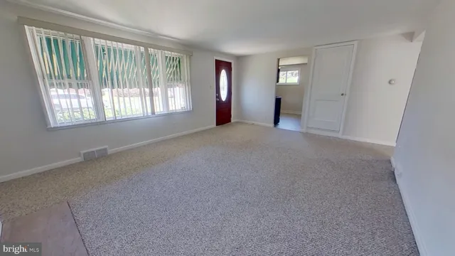 an empty room with windows and closet