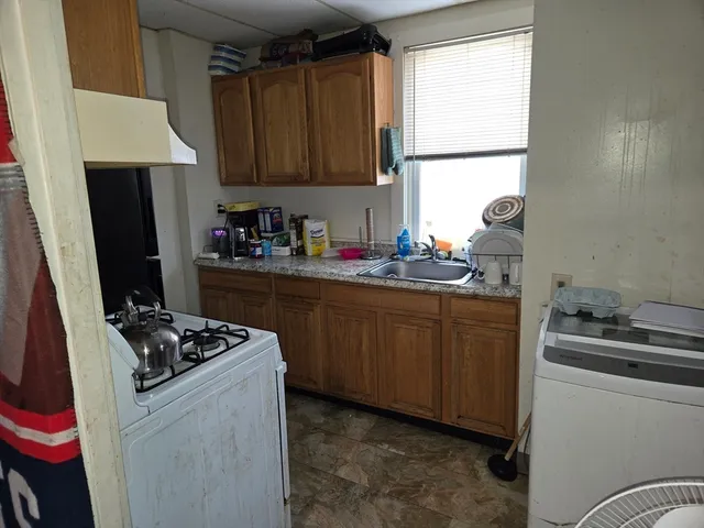 a kitchen with sink a stove and cabinets