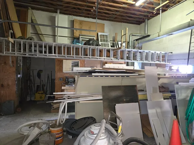 a room with stainless steel appliances kitchen island granite countertop a table chairs and a wooden floor