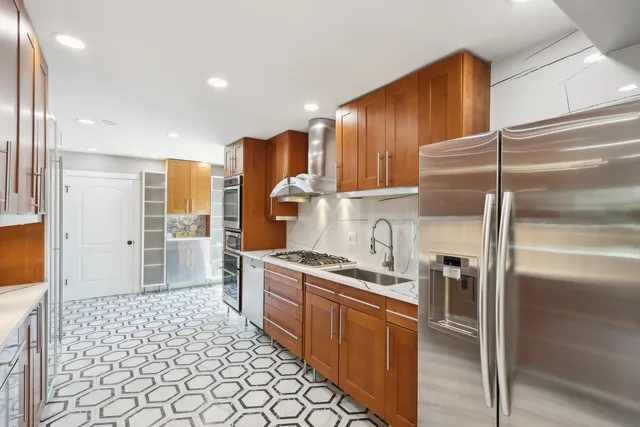 a kitchen with stainless steel appliances granite countertop a stove a sink and a refrigerator