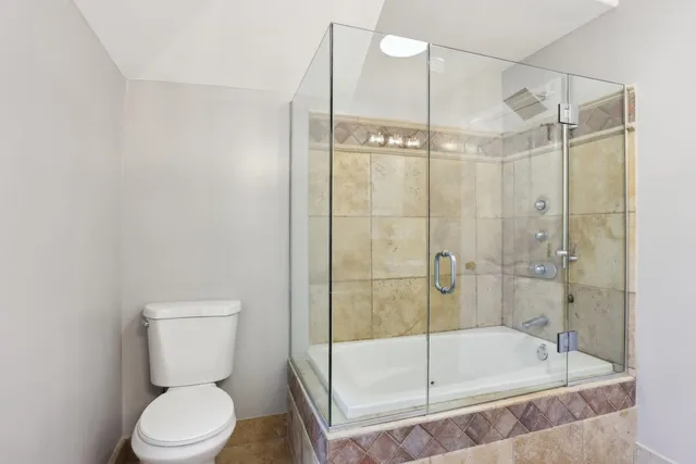 a bathroom with a toilet a sink and mirror