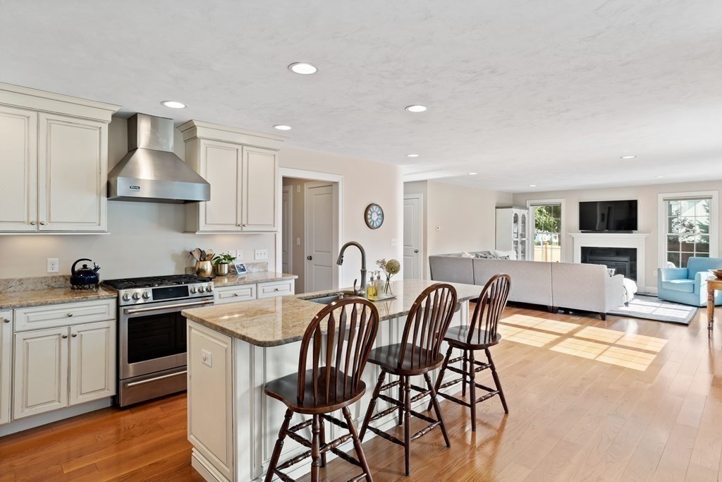 145 Old Farm Way Ayer, MA 01432 - Photo 13 of 39 a kitchen with stainless steel appliances granite countertop a stove top oven a sink a dining table and chairs
