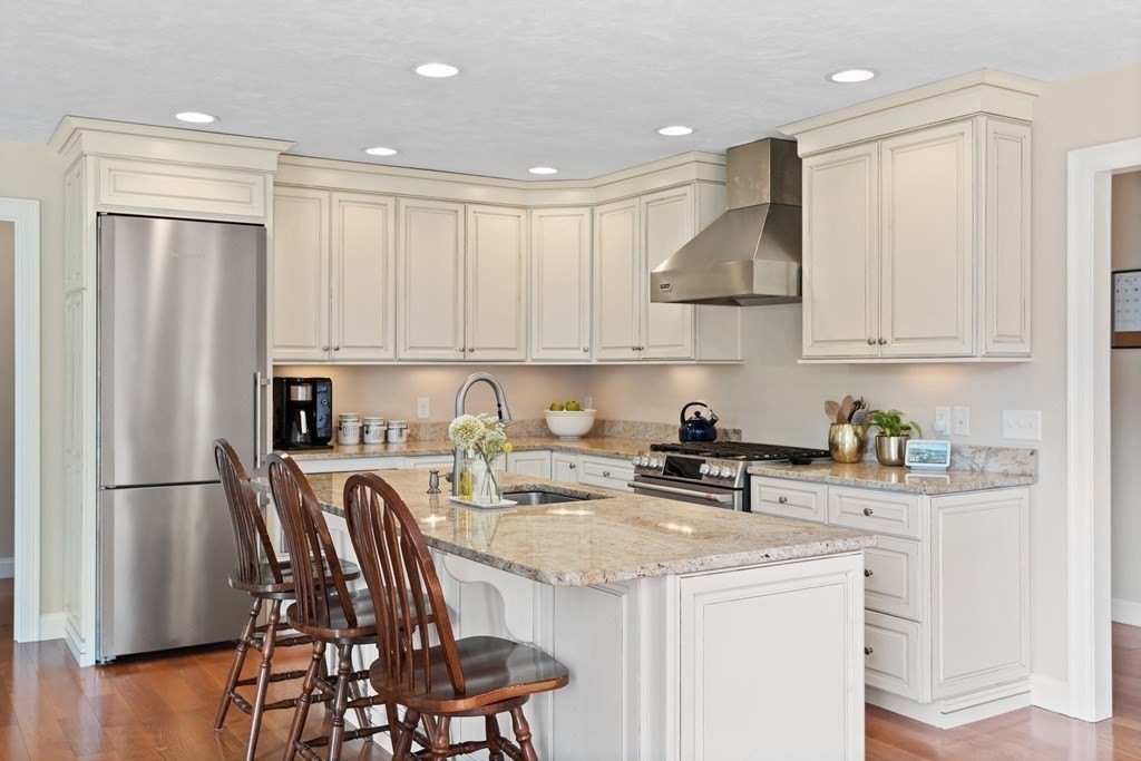 145 Old Farm Way Ayer, MA 01432 - Photo 14 of 39 a kitchen with stainless steel appliances granite countertop a stove a refrigerator a sink a table and chairs