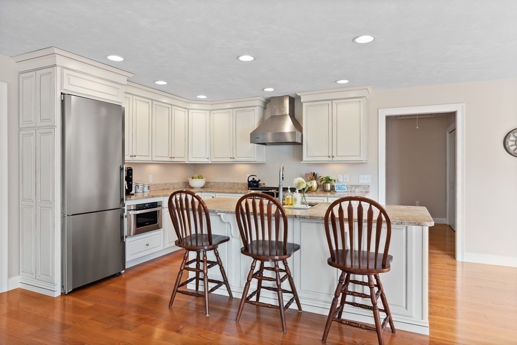 145 Old Farm Way Ayer, MA 01432 - Photo 15 of 39 a kitchen with stainless steel appliances granite countertop a dining table chairs refrigerator and microwave