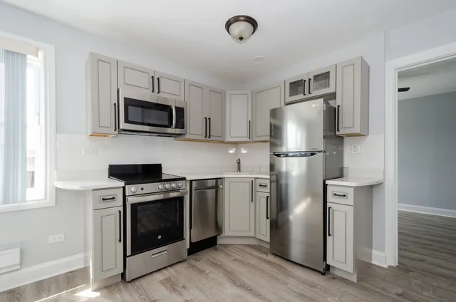 a kitchen with stainless steel appliances a refrigerator stove and microwave