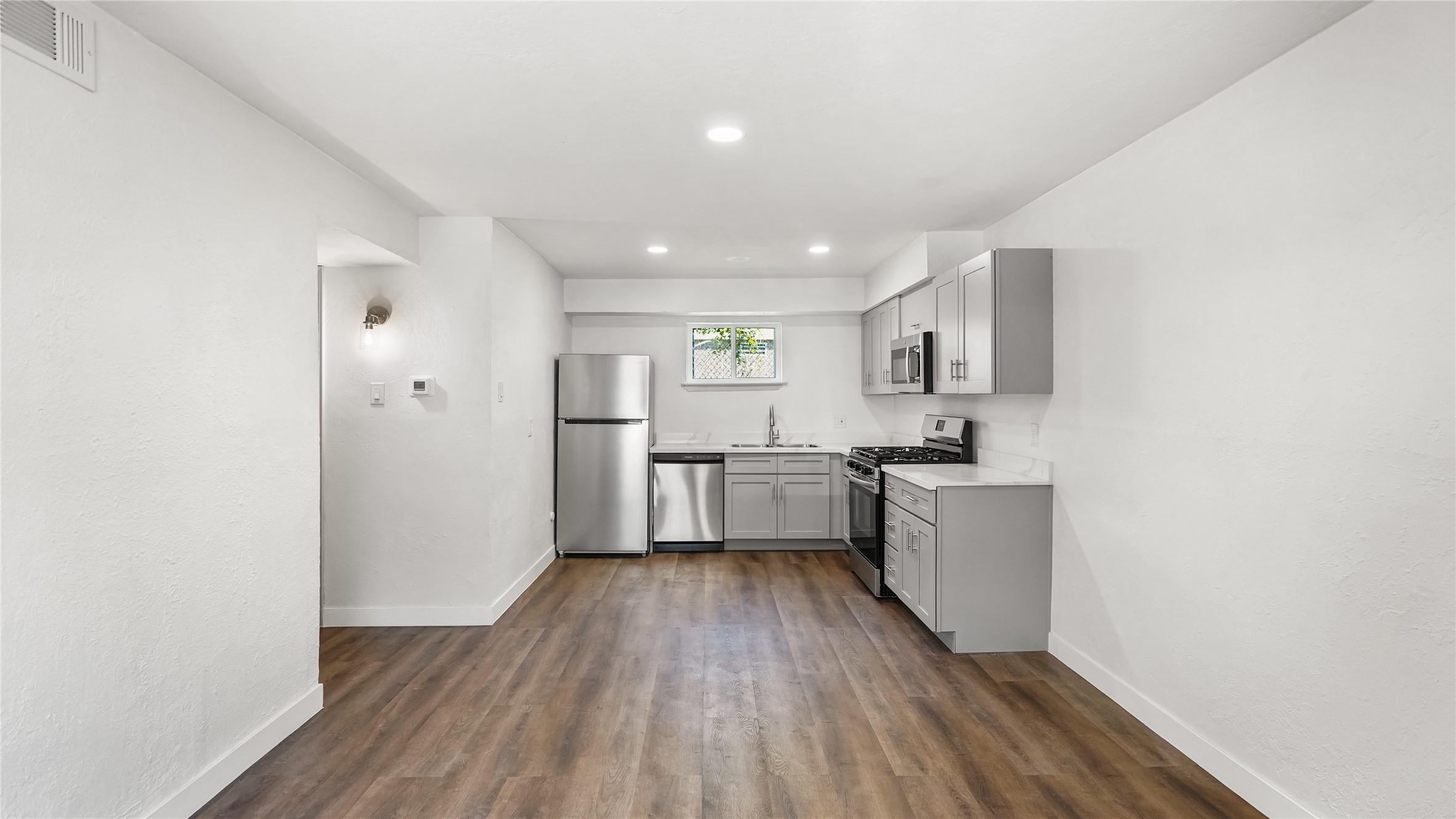a kitchen with a refrigerator and white cabinets