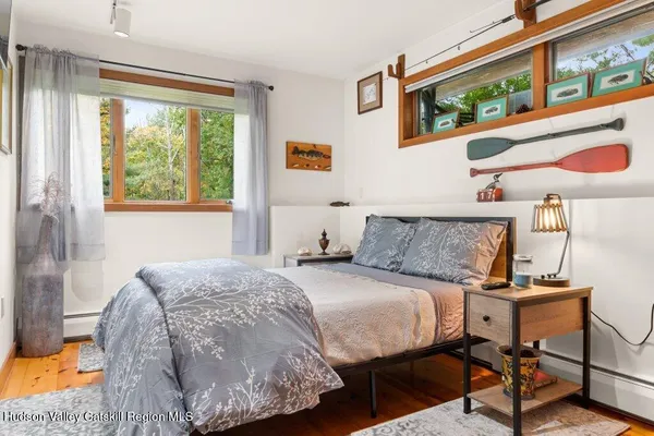 a bedroom with a bed and a dresser next to a window