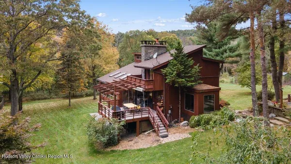 a view of a big house with a big yard plants and large trees